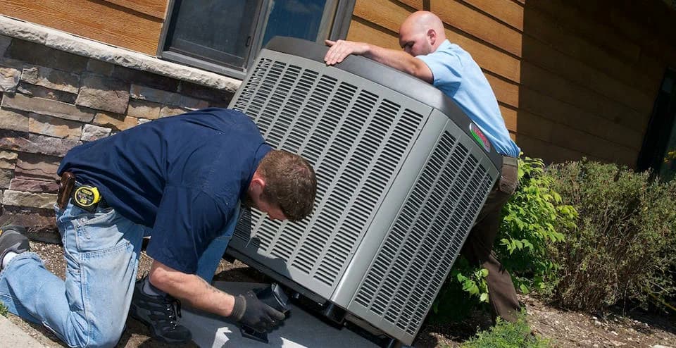 Crew replacing a residential air conditioner