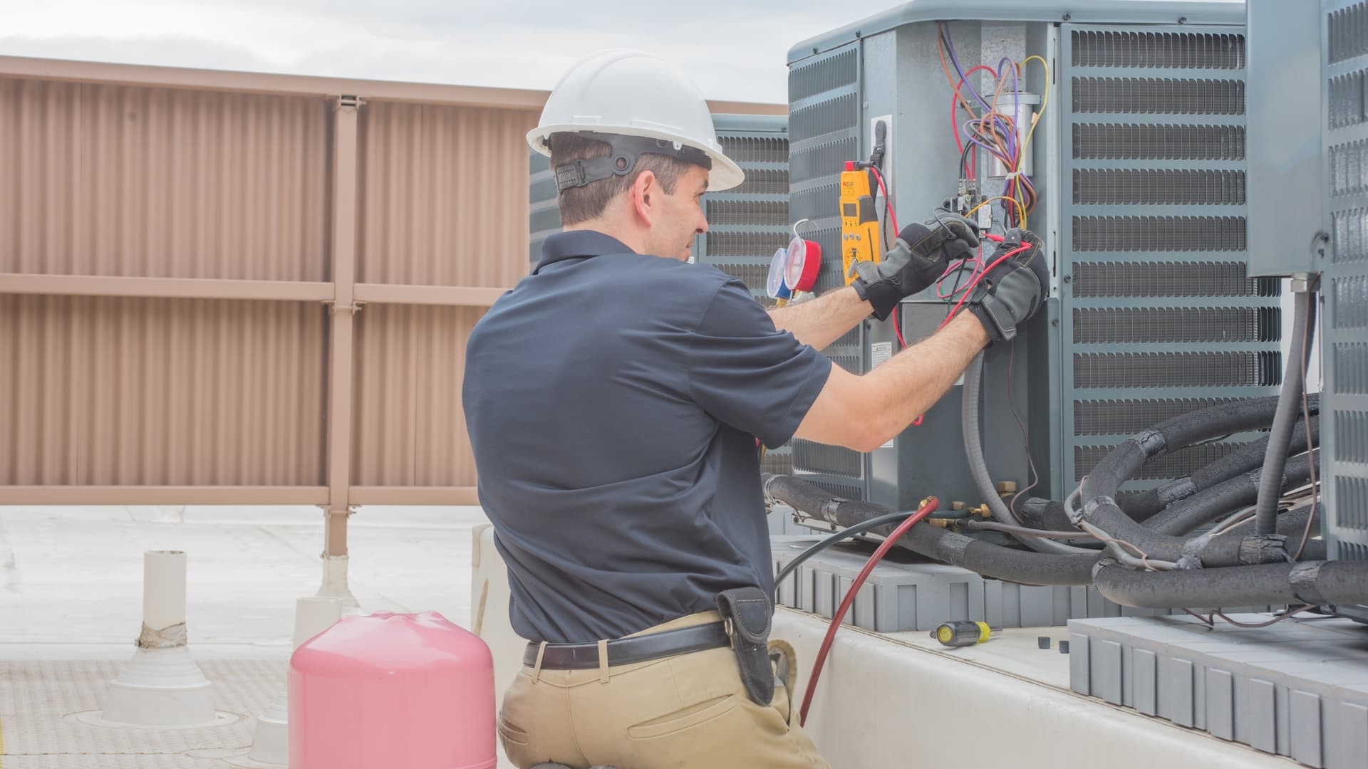 HVAC technician checking an outdoor condenser